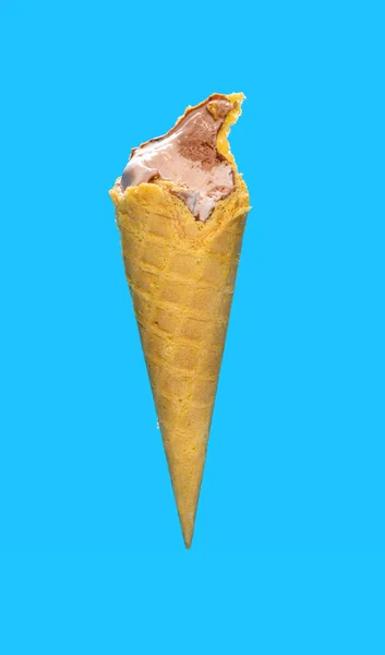 サイドビュー半分は青い背景にチョコレート風味のアイスクリームコーンを食べ — ストック写真