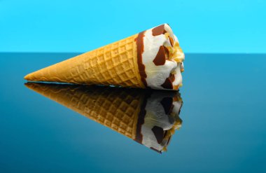 Taze vanilyalı dondurma külahı yansımalı bardakta.