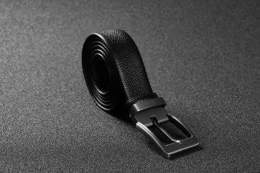 Koyu arka planda yatay kompozisyonda olan erkekler için zarif deri kemer kancası.