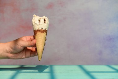 Güneşli bir sabahta birkaç ısırıkla taze şekerli dondurmayı tutan el.