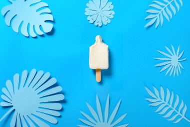 Üst manzara, yarı pişmiş peynir aromalı buzlu dondurma, birkaç ısırık mavide, el yapımı çiçek ve yapraklar.