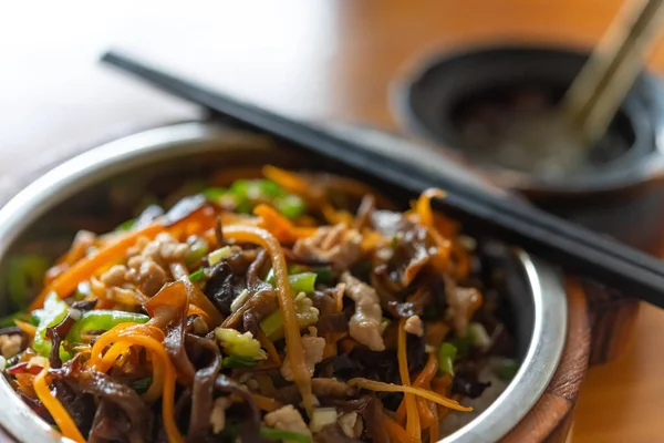 Yan gözle domuz eti, mantar, havuç, pirinç ve çorba dilimleri.