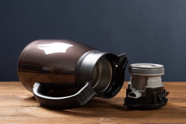 Yatay bileşimde kapağı açık paslanmaz çelik bir termos şişesi.