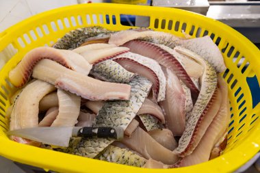 Plastik bir sepetteki balık dilimleri.