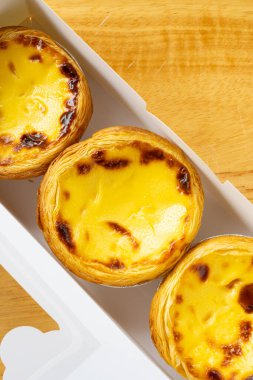 Dikey kompozisyonda bir kutuda üst görünüm Portekiz yumurtalı tartları