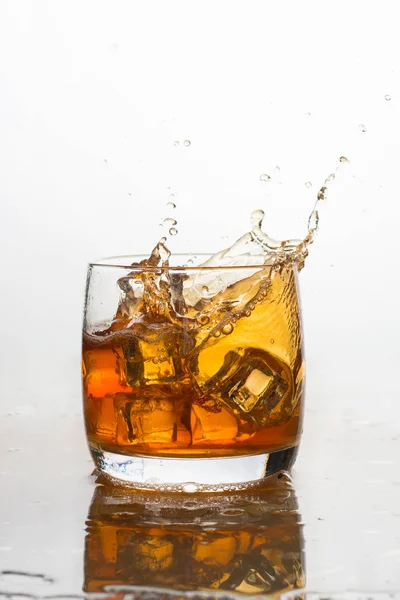 Whisky mit Eis im Glas mit Spritzern — Stockfoto