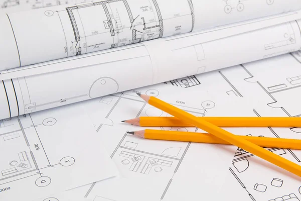 Pencils and paper engineering house drawings and blueprints. Royalty Free Stock Images