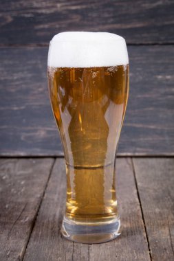 koyu ahşap masa üzerinde bir bardak fıçı bira Lager