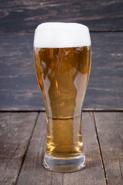 koyu ahşap masa üzerinde bir bardak fıçı bira Lager