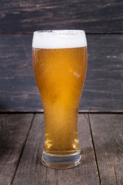 koyu ahşap masa üzerinde bir bardak fıçı bira Lager