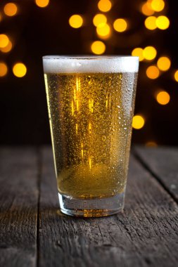 koyu ahşap masa üzerinde bir bardak fıçı bira Lager
