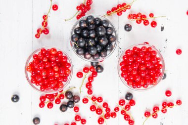 Beyaz ahşap zemin üzerinde siyah ve kırmızı üzümü