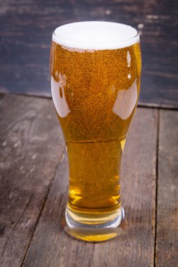 koyu ahşap masa üzerinde bir bardak fıçı bira Lager