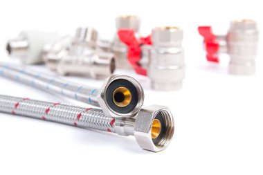 Tesisat kapısı valfleri, esnek su hortumu ve beyaz arka plana monte edilmiş aletler.