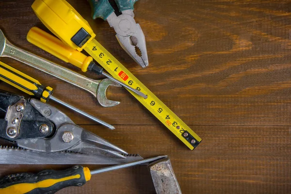 Old hand construction tools on a wooden surface