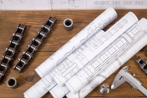 Engineer work. Drawings, measuring tools and details of chains on the table.