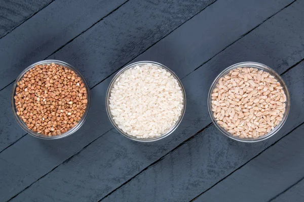 Different types of cereals on wooden background — Stock Photo, Image