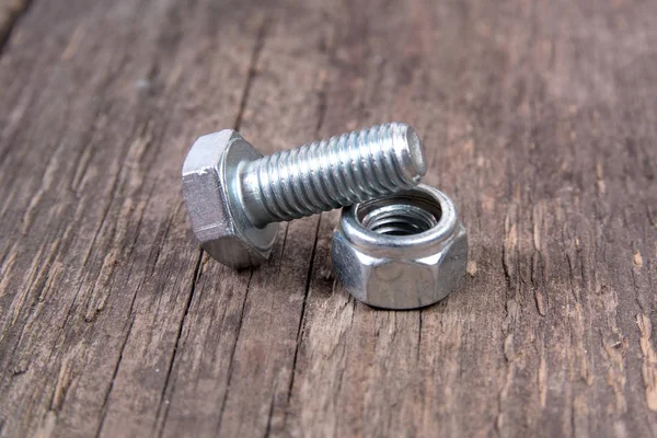 ahşap arka plan üzerinde cıvata ve somun