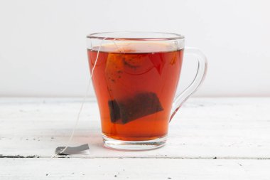 beyaz masada çay poşeti ile cam fincan