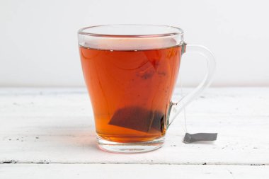 beyaz masada çay poşeti ile cam fincan