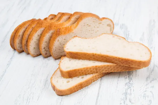 Gesneden tarwe brood op witte tafel — Stockfoto