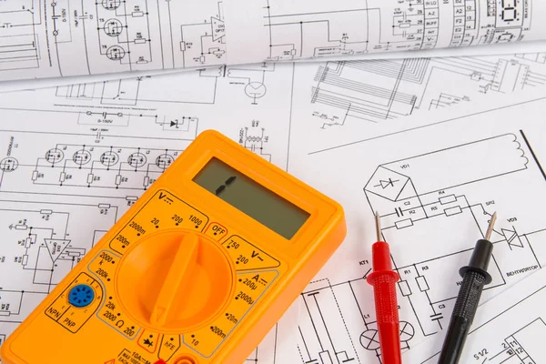 Electrical engineering drawings and digital multimeter.