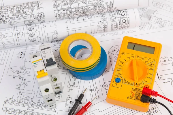 Elektrik mühendisliği çizimleri, yalıtım bandı, modüler devre kesici ve dijital multimetre.