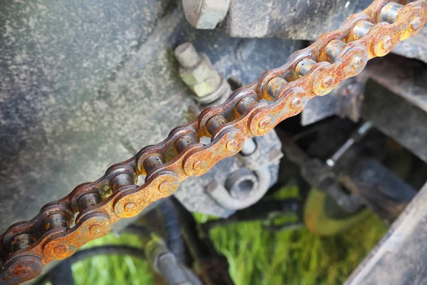 Chain drive. Rusty driving roller chain on the drive sprocket in operation
