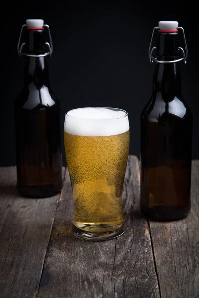 Стакан пива и бутылка на темном фоне — стоковое фото