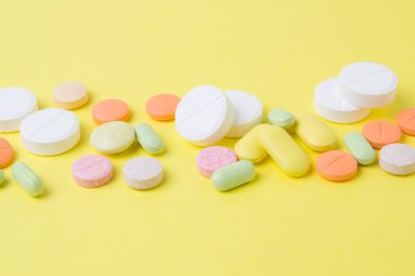 sarı bir arka plan üzerinde ilaç hapları, ilaçlar ve antibiyotikler