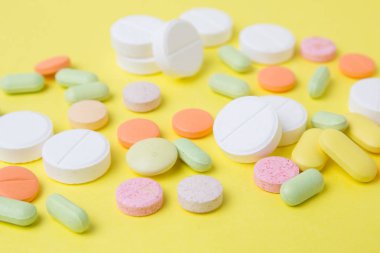 sarı bir arka plan üzerinde ilaç hapları, ilaçlar ve antibiyotikler