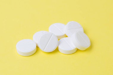 Beyaz haplar sarı arka planda