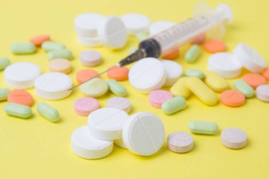 sarı bir arka plan üzerinde ilaç hapları, ilaçlar ve antibiyotikler