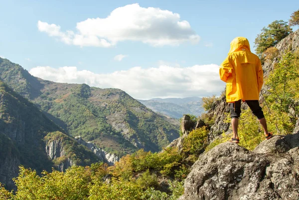 Bir adam bir kayada duran ve dağlar seyir 