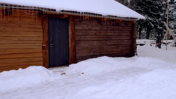 Gran casa rural de madera marrón durante una nevada — Vídeo de stock