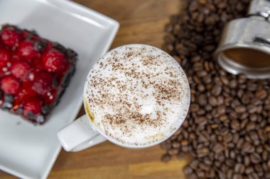 Kapuçino çilek peynir pasta ve kahve çekirdekleri ile kahve