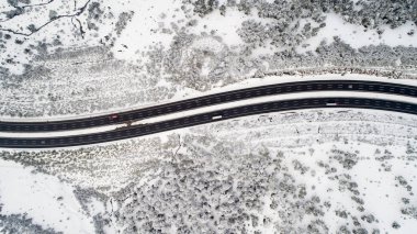 Havadan görünümü kış asfalt karayolu ya da otoyol yol araçları ile kırsal kesimde ve kargo lojistik kamyon kış zamanında. Kış manzarası