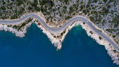 Sahil şeridi nin hava manzarası ve bir yol deniz manzarası. Araba, Türkiye'nin güneşli Akdeniz kıyı şeridi boyunca uzanan boş asfalt yoldan aşağı sürüyor. Doğal sahil yolunda turist araba yolculukları .