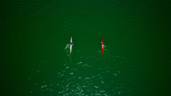 Aerial drone bird\'s eye view of sport canoe operated by team of young men in green sea waters. Aerial view of rowing team in Mugla  Turkey