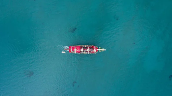 Aerial view of sea and yacht. Sailing ship in the middle of ocean, top view, summer background. Amazing view to Yacht sailing in open sea at sunny day