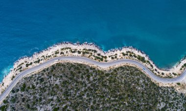 Sahil şeridi nin hava manzarası ve bir yol deniz manzarası. Araba, Türkiye'nin güneşli Akdeniz kıyı şeridi boyunca uzanan boş asfalt yoldan aşağı sürüyor. Doğal sahil yolunda turist araba yolculukları .
