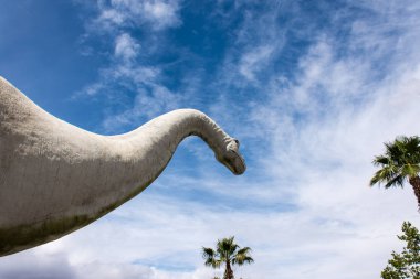 30 Haziran 2017 - Cabazon, California: A brontosaurus heykel bakar kadar bulutlu gökyüzü içine Cabazon dinozorlar, Kaliforniya'da Interstate 10 boyunca yol kenarına yerleştirilen bir cazibe.