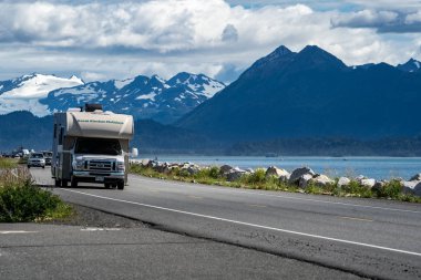 HOMER, ALASKA - AUGUST 3, 2018: RV recreational vehicle drives down the Homer Spit. This is a popular spot in the summer for camping clipart