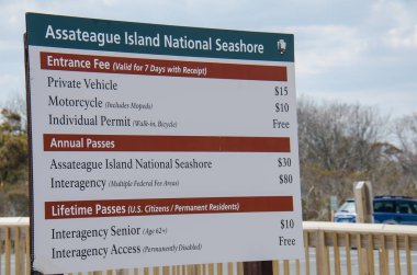 March 30 2018 - Ocean City, Maryland: Assateague Island National Seashore entrance fees sign shows the amount for visitors need to pay clipart