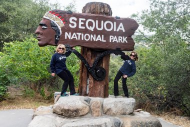 22 Mayıs 2018 - Sequoia, California: California Sequoia National Park için oturum açın. İki kadın turist yetişkin kadın pozlar işareti ile