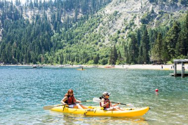 Emerald Bay Tahoe Gölü üzerinde çift bir kayık satır iki arkadaşlar. Takım çalışması, birlikte çalışma arkadaşlık, kavram