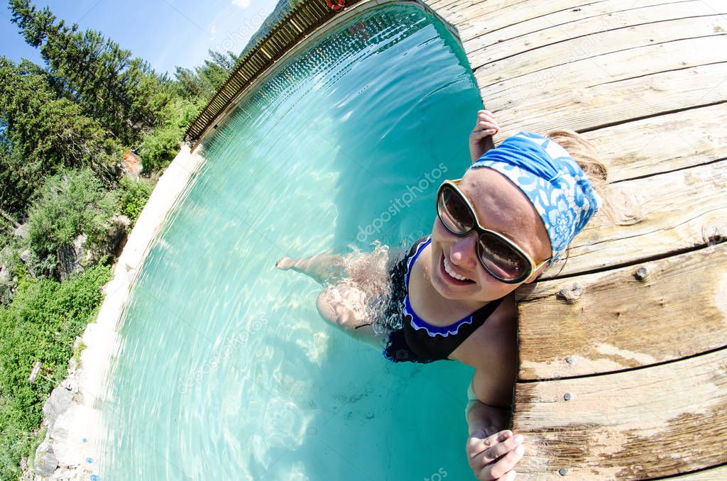 An adult female goes for a swim at Granite Creek Hot Springs, a natural hot spring in Jackson Hole, Wyoming. Fisheye view