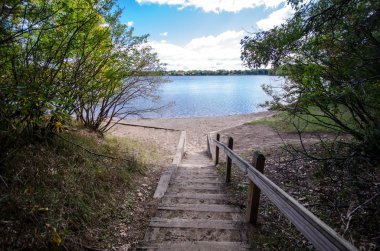 Lake Ann in Zimmerman Minnesota, wide angle view with ripples in the water. Steps going down to lakeshore clipart