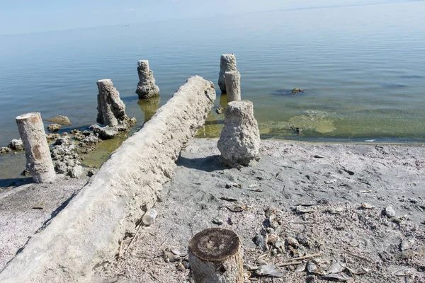 Terk edilmiş dock ayağı Salton Denizi Bombay Beach, California plajda oturmak