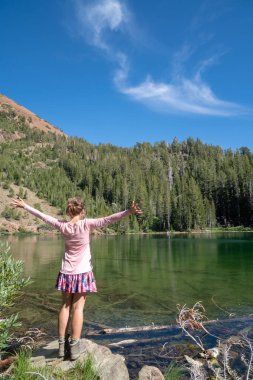 Güneşli bir günde manzarayı Heart Lake Mammoth Lakes California, güzel ve genç birbayan. Arka yan yana kamera, sevinç içinde kaldırdı kollarını